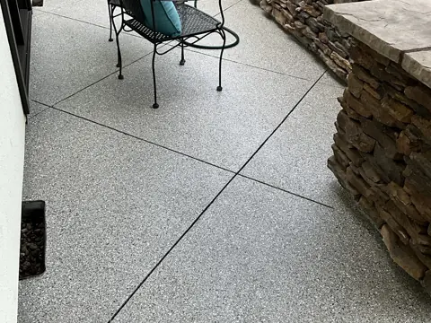 Corky M.'s coated front patio beside a stacked-stone wall.