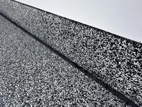Close-up of the flake coating where the floor meets the wall in Stein J.'s garage.